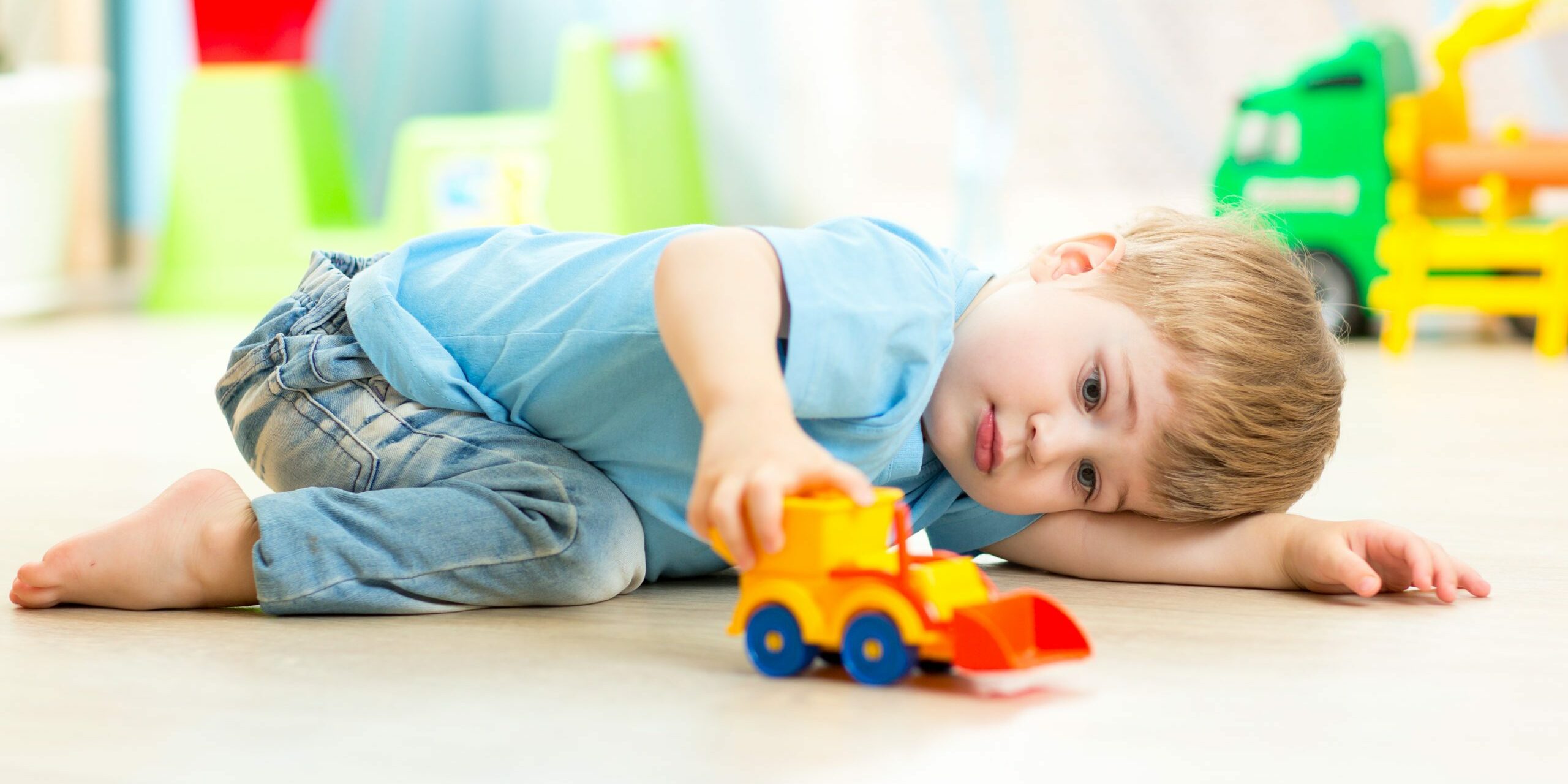 child boy toddler playing with toy car indoors